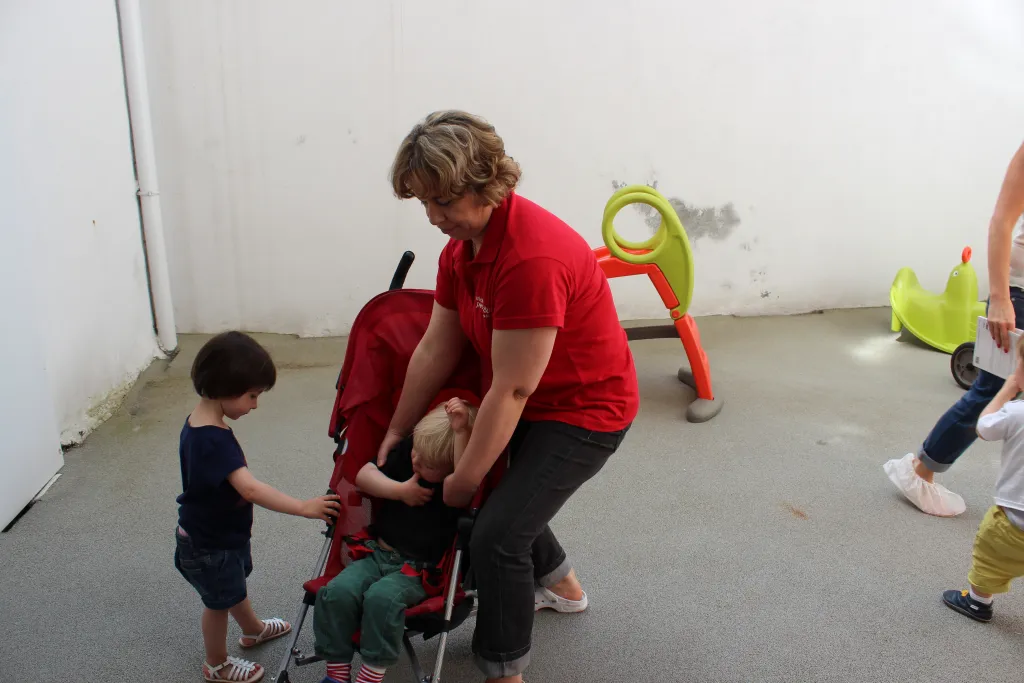 Femme aide un enfant dans une poussette